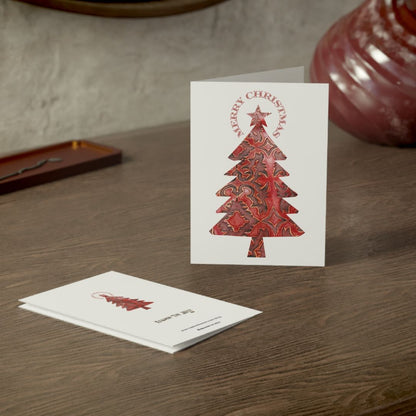 Christmas card with red tree design on a wooden surface