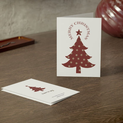 White card with red Christmas tree design and 'Merry Christmas' text on a wooden surface.