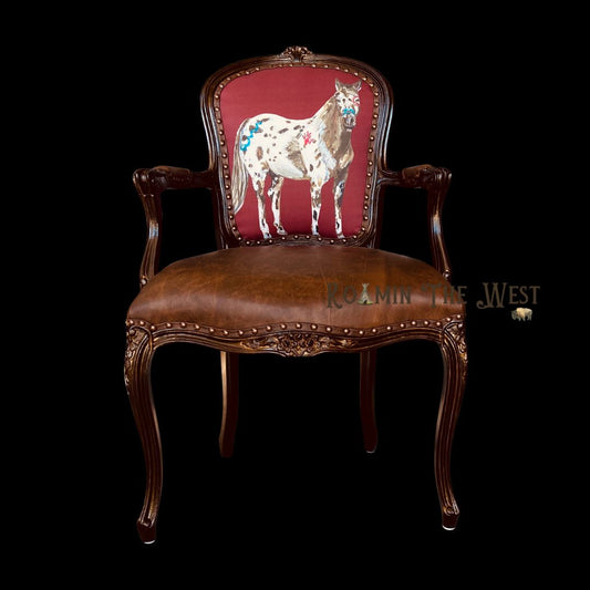 Western upholstered chair with horse design on red backrest against a black background
